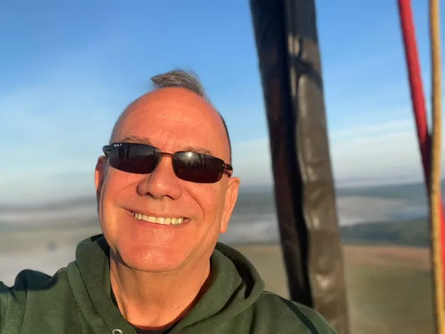 Kiko smiling in the basket of a hot air balloon